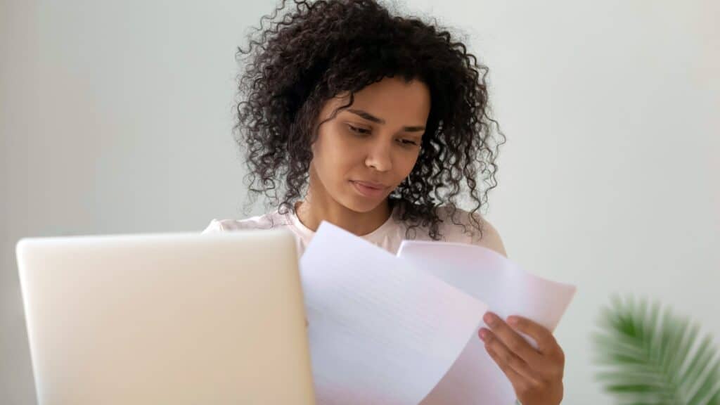 HR employee sitting at her desk reading mandatory employee handouts