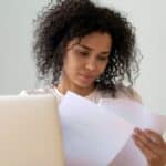 HR employee sitting at her desk reading mandatory employee handouts