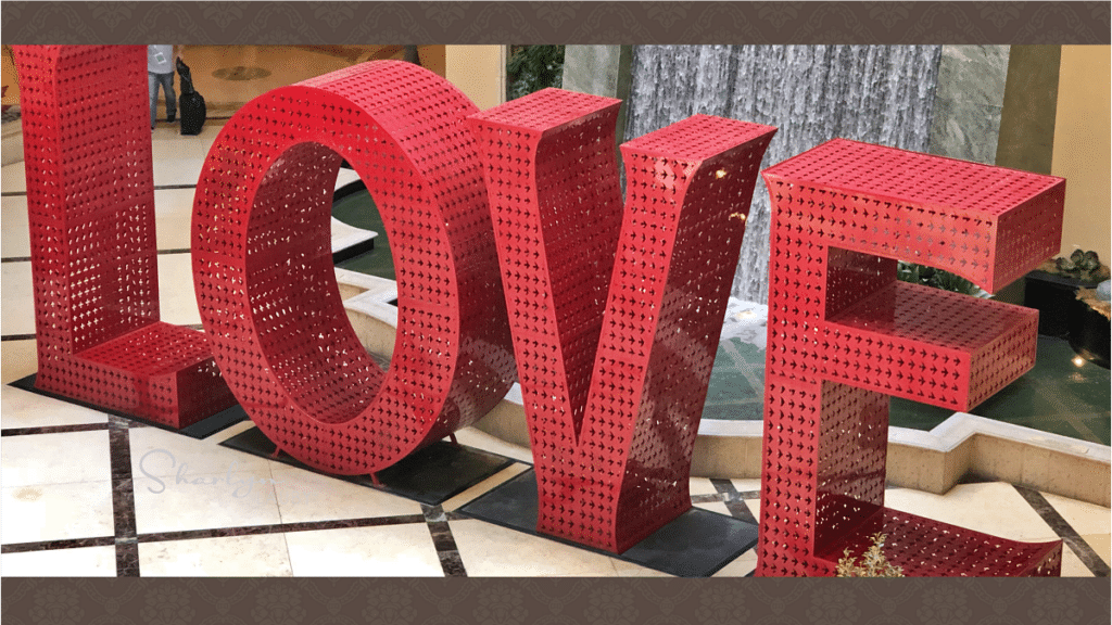 sculpture spelling love in front of a fountain stay interviews