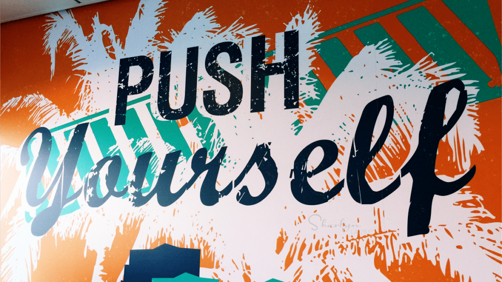 painted wall sign push yourself for wellness like with Peloton