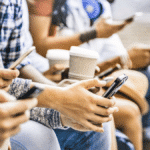 multicultural group on smartphones doing social media background checks