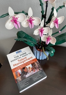 The SHRM Essential Guide to Talent Management by Sharlyn Lauby book on table